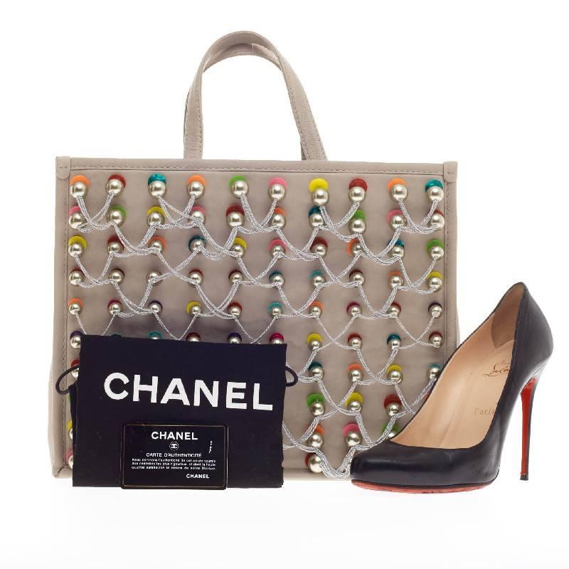 This authentic Chanel Pearl Embroideries Tote Calfskin Large released during the brand's Spring/ Summer 2014 Collection is a one-of-a-kind runway piece showcasing Chanel's avant-garde style. Crafted in gray calfskin leather, this playful tote