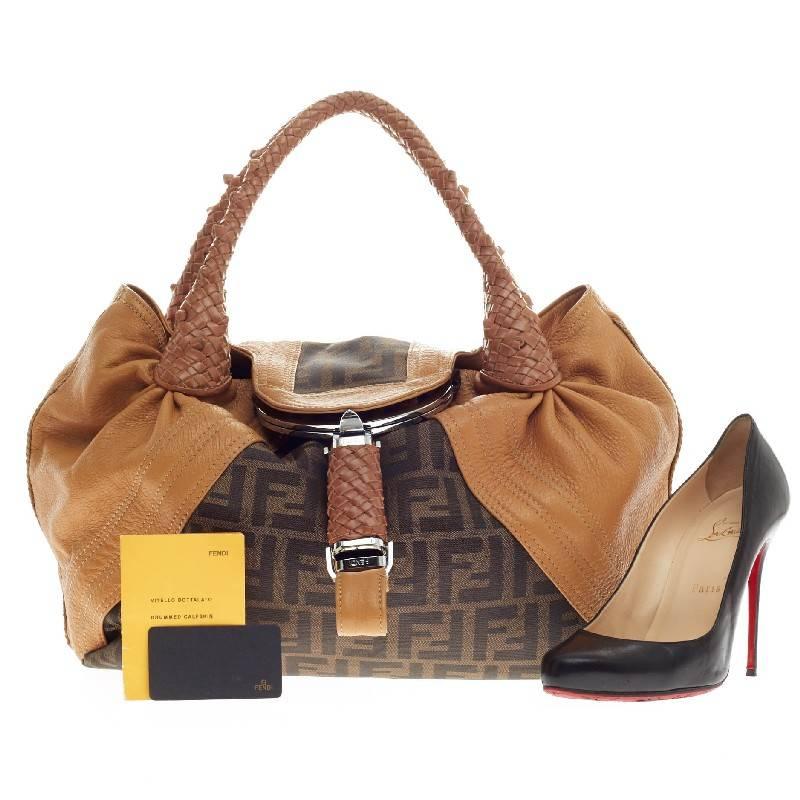 Diese authentische Fendi Spy Bag Zucca Canvas and Leather Medium in braunem Fendi Monogramm Zucca Print Canvas mit hellbraunen Lederdetails zeigt eines der beliebtesten Designs der Marke. Diese verführerische Tasche hat geflochtene Griffe aus