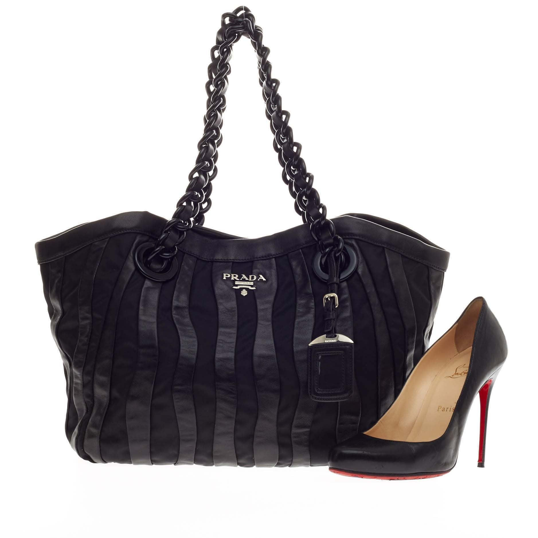 This authentic Prada Waves Chain Tote Leather and Tessuto Large is a stylish an functional everyday bag perfect for the modern woman. Crafted from alternating black nylon and leather stripes, this pleated bag is accented with silver raised Prada