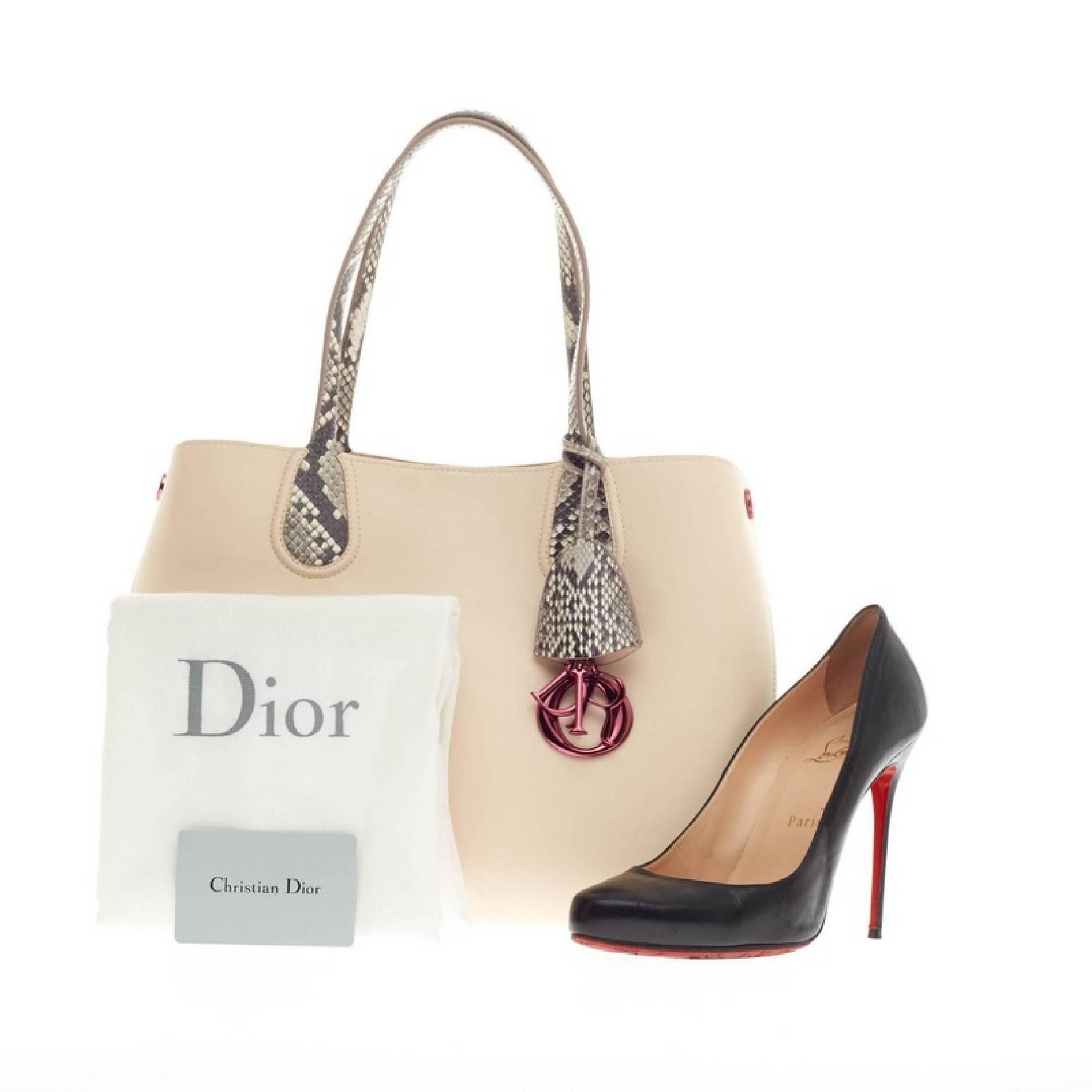 This authentic Christian Dior Addict Shopping Tote Leather and Python Small presented in the brand's Cruise 2014 Collection is luxuriously sleek and modern in design perfect for work or everyday excursions. Crafted in light pink supple calfskin