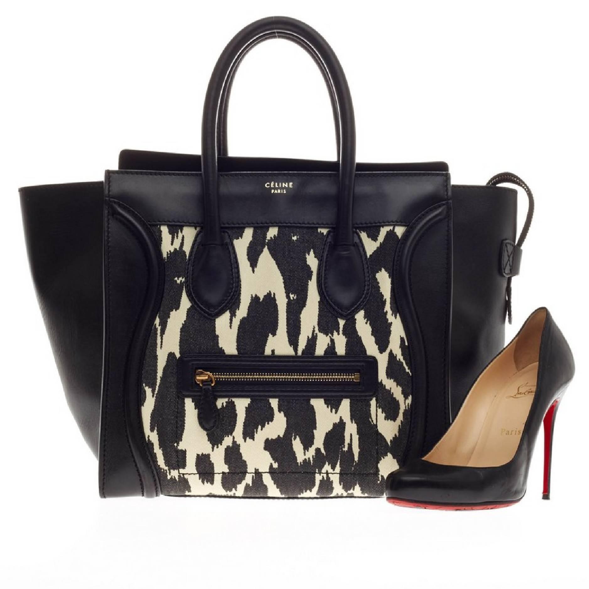 This authentic Celine Luggage Canvas and Leather Mini is the quintessential It bag beloved by many fashionistas. Constructed in black leather with a striking leopard print canvas design, this eye-catching yet stylish tote features dual-rolled
