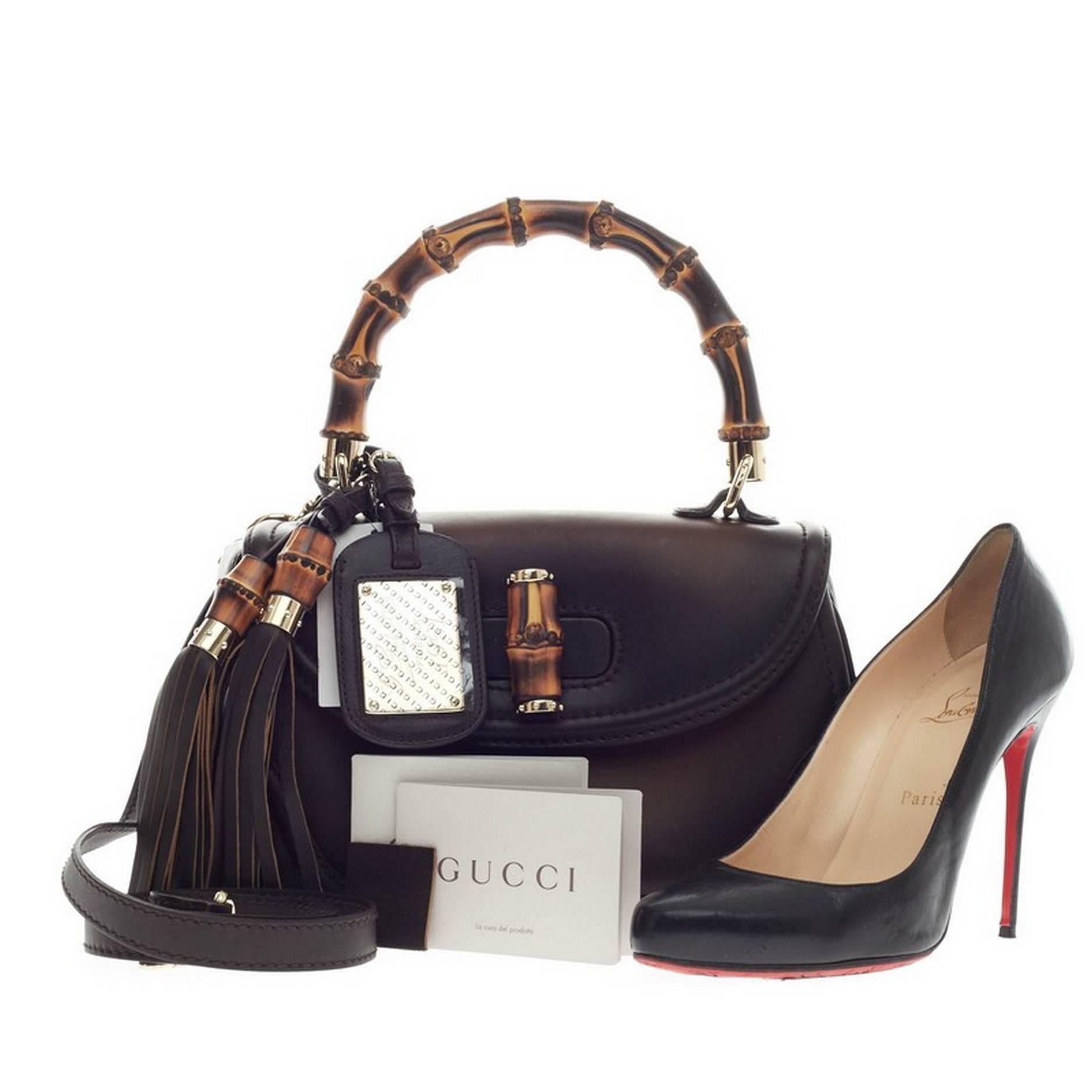 This authentic Gucci New Bamboo 1921 Top Handle Leather Medium is unmistakably a classic Gucci design created in 2011 for Gucci's 90th Anniversary. Hand-crafted shaded dark brown leather, this reimagined iconic bag features a bamboo top handle,