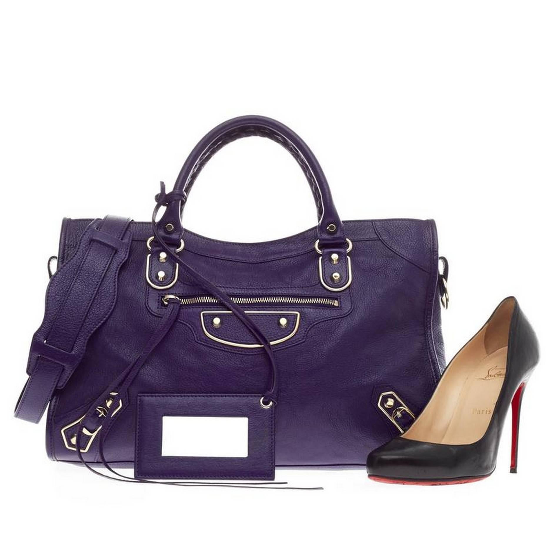 This authentic Balenciaga City Classic Metallic Edge Leather Medium in vivid deep blue is for the on-the-go fashionista. Constructed in shiny grain goatskin, this popular bag features braided woven handle straps, long fringe details, and iconic