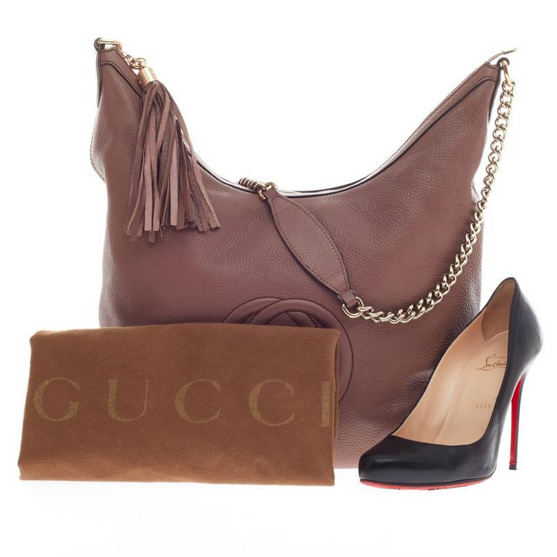 This authentic Gucci Soho Hobo Chain Strap Leather Medium is simple yet stylish in design. Crafted with pebbled leather in brown and purple undertones, this hobo features gold chain straps with leather pads, fringe tassel, and signature interlocking