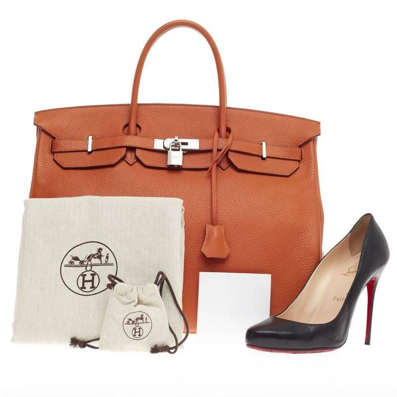 This authentic Hermes Birkin Orange Clemence with Palladium Hardware 40 is the quintessential dream bag for any fashionista. Crafted in iconic and scratch-resistant orange clemence leather, this luxurious, oversized tote features dual-rolled top