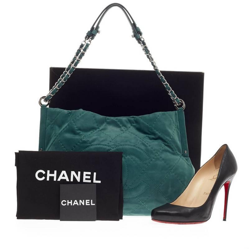 This authentic Chanel Timeless Chain Shopping Tote Iridescent Calfskin Medium presented in the brand's Spring 2012 Collection is made for everyday use. Crafted in turquoise quilted iridescent calfskin leather, this chic shoulder bag features