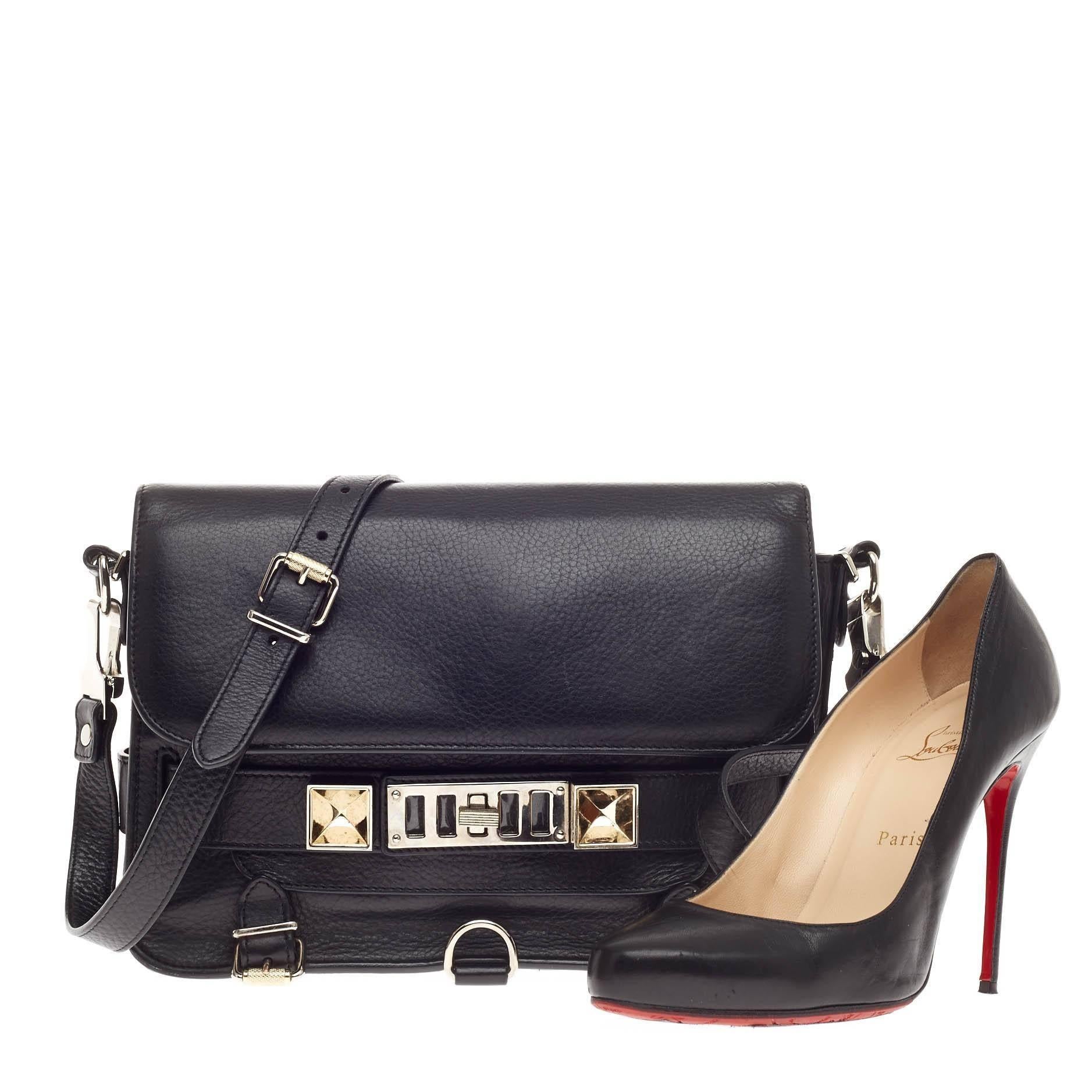 This authentic Proenza Schouler PS11 Crossbody Leather Medium loved by fashionistas is constructed in a black leather. The square body is accented with silver faceted cubes, turn lock fastening grill closure, buckle detailing at the base, exterior