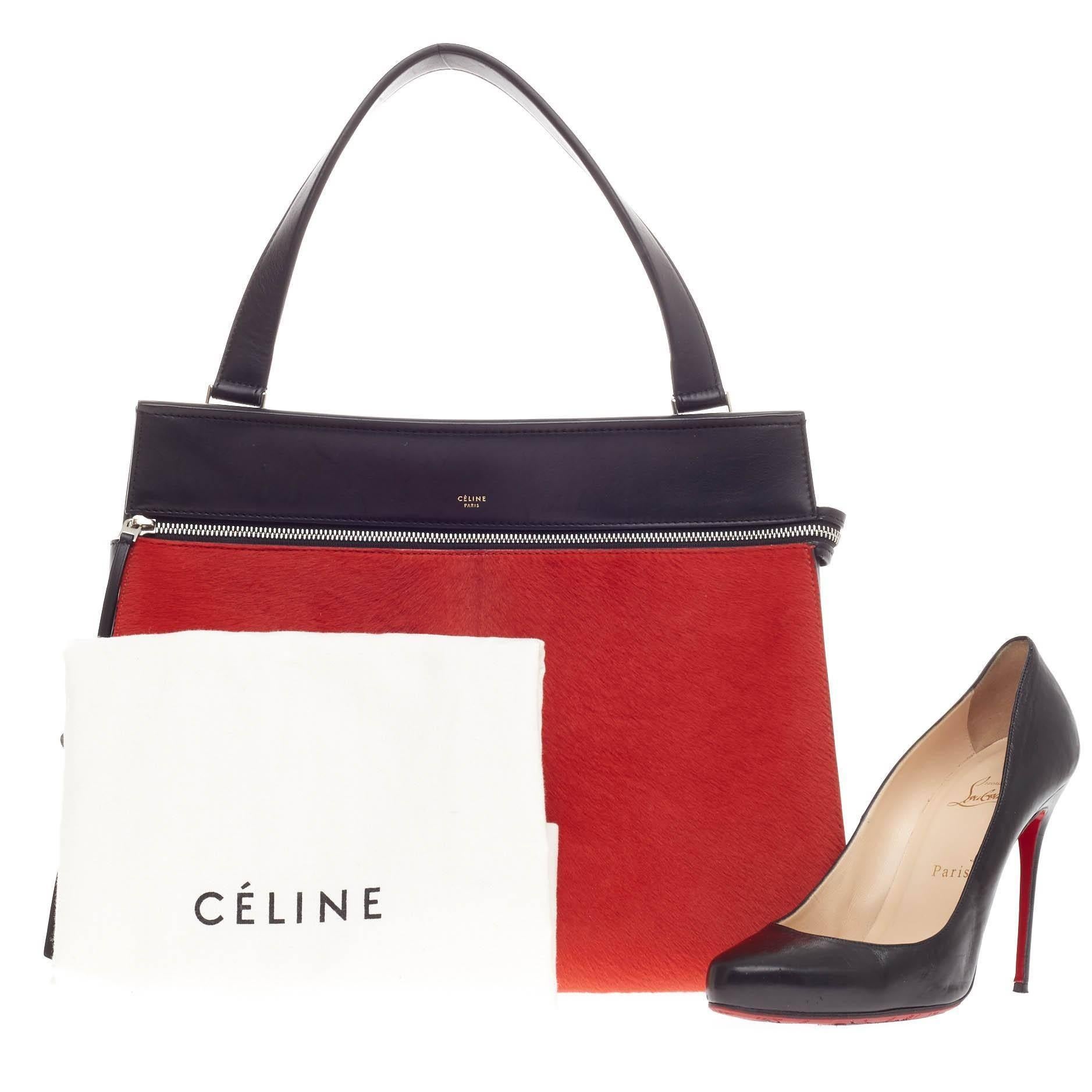 This authentic Celine Edge Bag Pony Hair Medium is the quintessential Céline design mixing minimalism with luxury. The front face of the bag is crafted with luxurious, eye-catching red pony hair and smooth black leather. The bag features a large