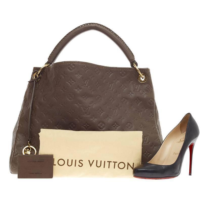 This authentic Louis Vuitton Artsy Monogram Empreinte Leather MM is as elegant as it is sturdy. Crafted in classic brown ombre embossed leather with subtle LV monogram imprints, this luxurious and refined hobo features a single looped braided top