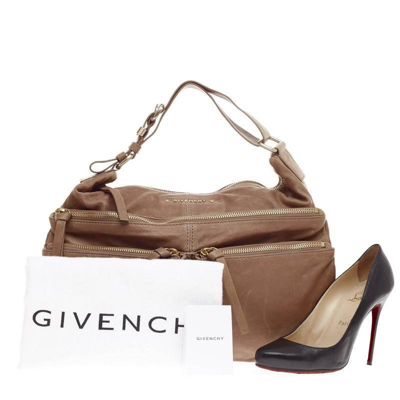 This authentic Givenchy Zip Multi Pocket Hobo Leather Medium is simple and sophisticated in design, ideal for work or everyday use. Crafted in distressed neutral tan leather, this hobo features multiple front zip pockets, adjustable wide shoulder