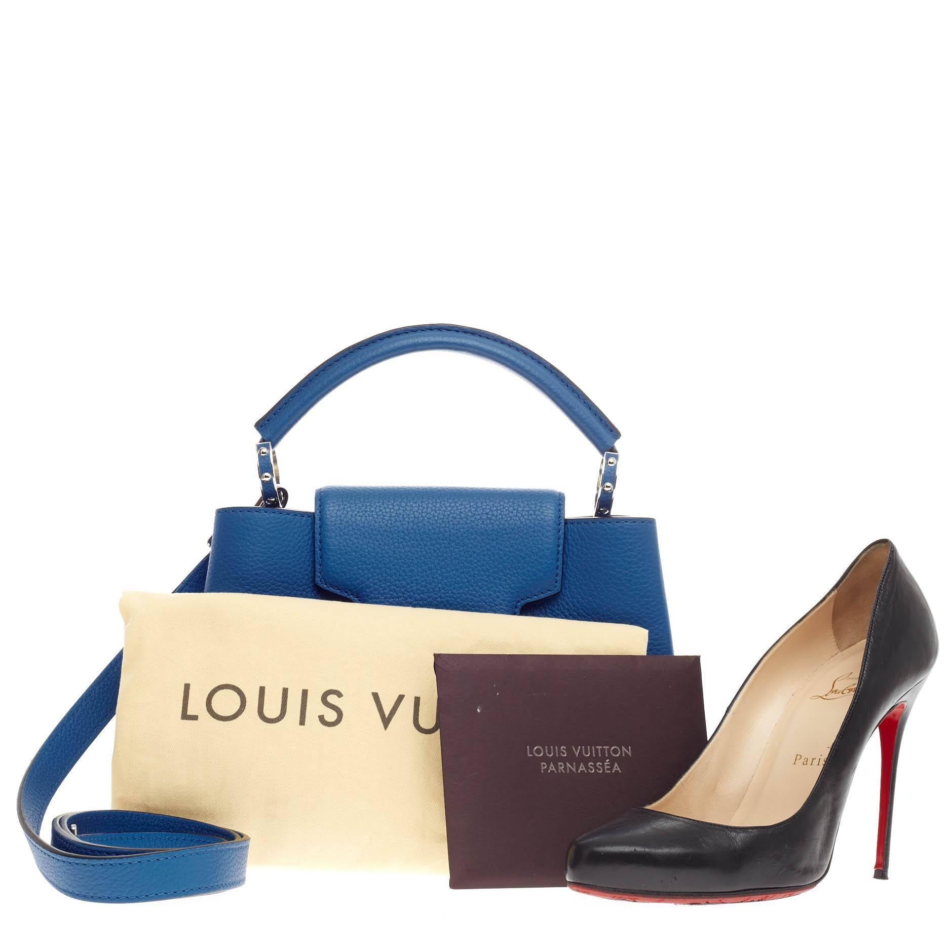 This authentic Louis Vuitton Capucines Leather BB is sophisticated and fresh in design from the brand's Fall 2013 Collection inspired by its Parisian heritage. Crafted in outremer royal blue taurillon leather, this ultra-chic petite bag features a