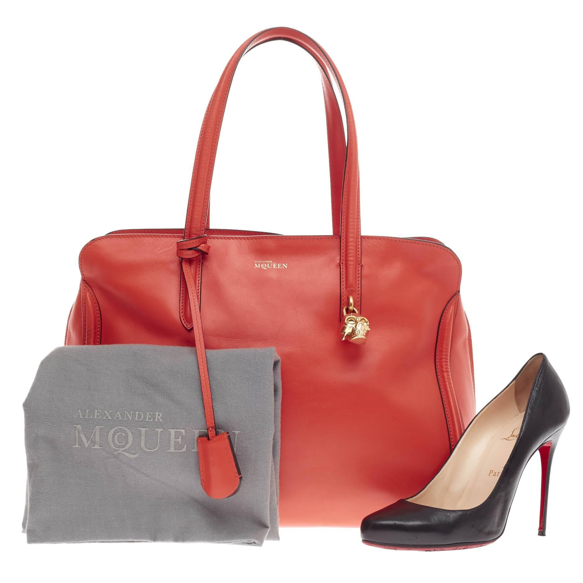 This authentic Alexander McQueen Padlock Zip Around Tote Leather Medium is a sleek and stylish accessory made for every fashionista. Crafted in stunning orange leather, this functional tote features dual flat handles, defined edges, signature gold