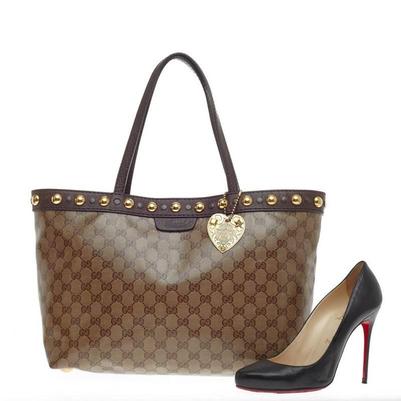 This authentic Gucci Babouska Tote GG Coated Canvas Medium is sophisticated and luxurious in design ideal for everyday use. Crafted in brown GG coated canvas, this tote features dark brown leather trims and handles, gold studded trim at the opening,