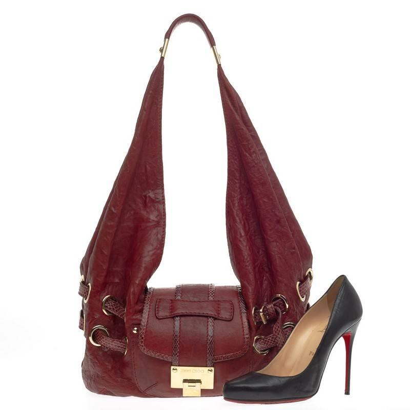 This authentic Jimmy Choo Ruse Messenger Leather and Snakeskin is a unique and eye-catching hobo-style messenger made for everyday excursions. Crafted in dark red leather with stand-out snakeskin trims, this messenger bag features a long looped