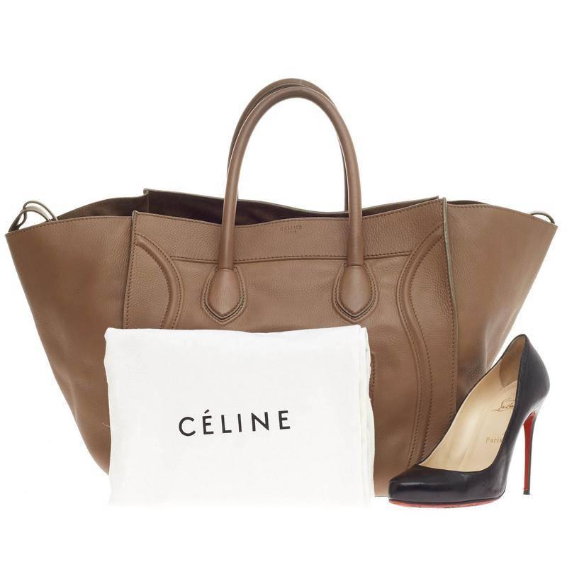 This authentic Celine Phantom Smooth Leather Large is one of the most sought-after bags beloved by fashionistas. Crafted from smooth brown leather, this oversized, minimalist tote features a braided zipper pull, dual-rolled handles, zip front