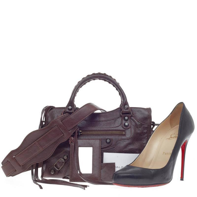 This authentic Balenciaga City Classic Studs Leather Mini is miniature in size but bold in style. Crafted in cigare fonce brown leather, this scaled-down city bag features braided woven handles, exterior zip pocket with long fringes details and