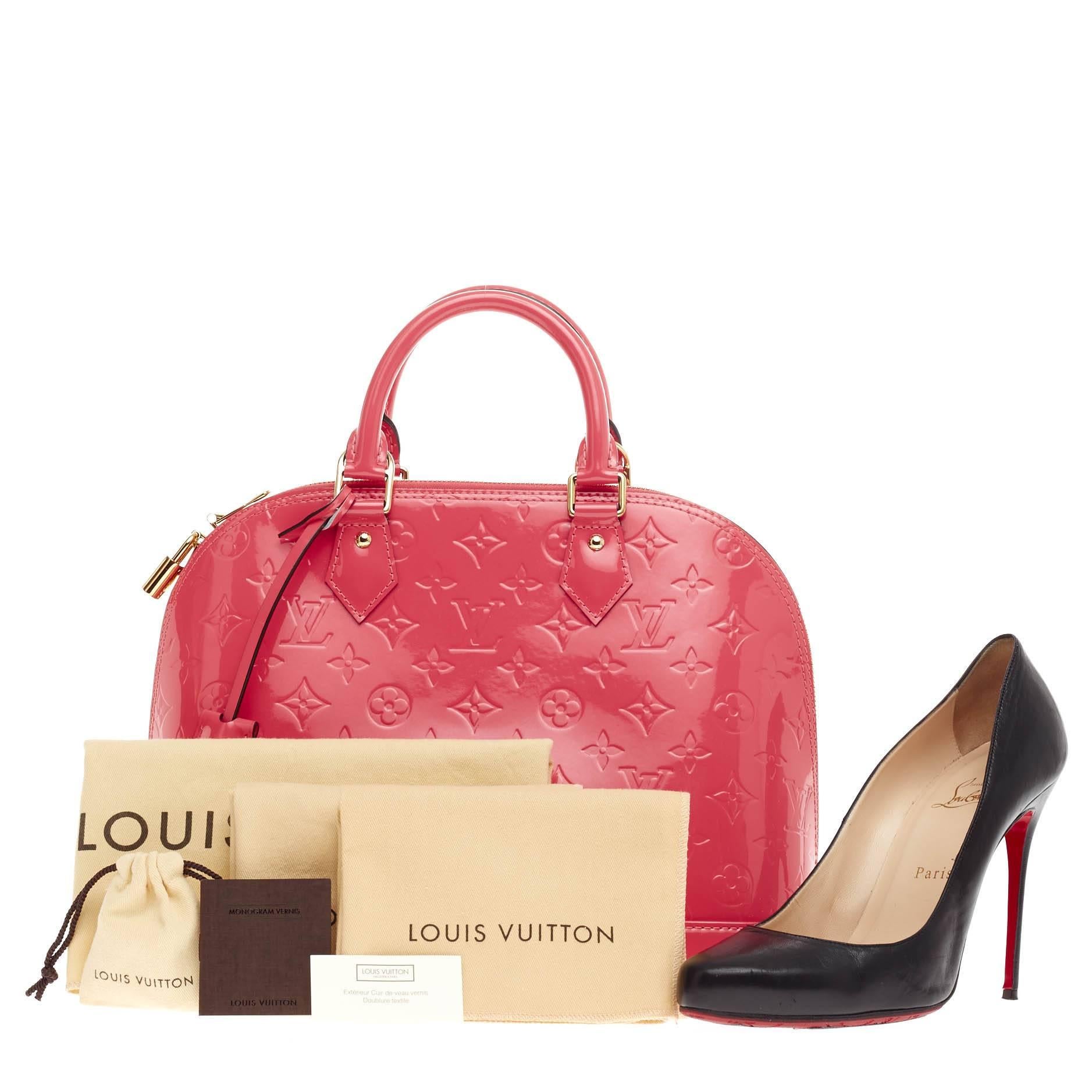 This authentic Louis Vuitton Alma Monogram Vernis PM is a fresh and elegant spin on a classic style that is perfect for all seasons. Crafted from Louis Vuitton's glossy vernis patent leather in beautiful rose pop pink, this dome-shaped satchel