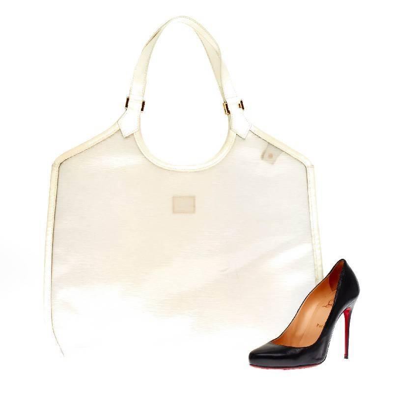 This authentic Louis Vuitton Plage Lagoon Bay Vinyl Epi Leather GM is a chic and modern tote crafted with sturdy transulescent epi leather and accented with white leather trim and brass hardware. Its wide top opening features a spacious interior