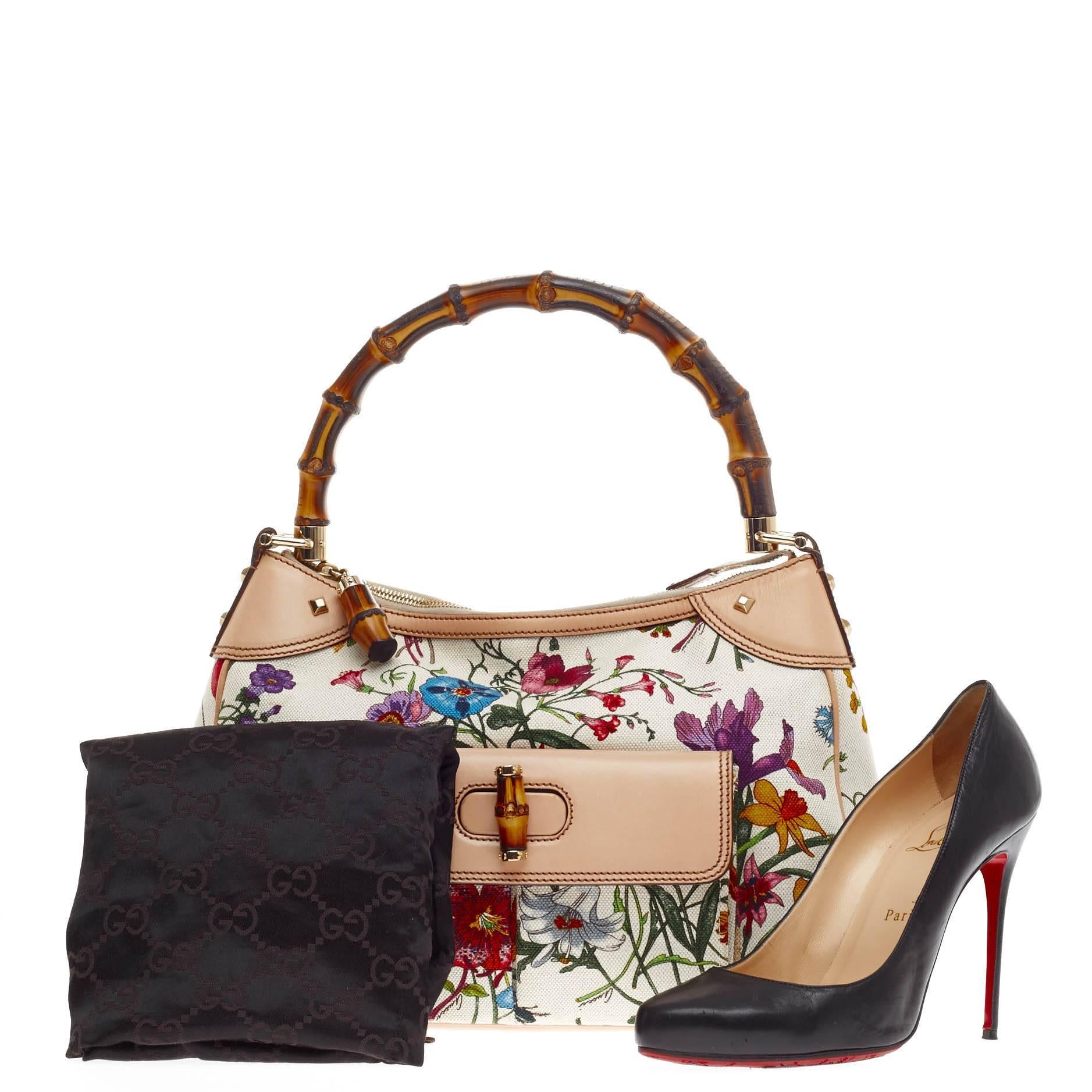 Diese authentische Gucci Bamboo Front Pocket Shoulder Bag Flora Canvas ist Ihr perfekter Begleiter für sommerliche Ausflüge. Diese exquisite Umhängetasche aus weißem Canvas mit dem für Gucci charakteristischen botanischen Blumendruck verfügt über
