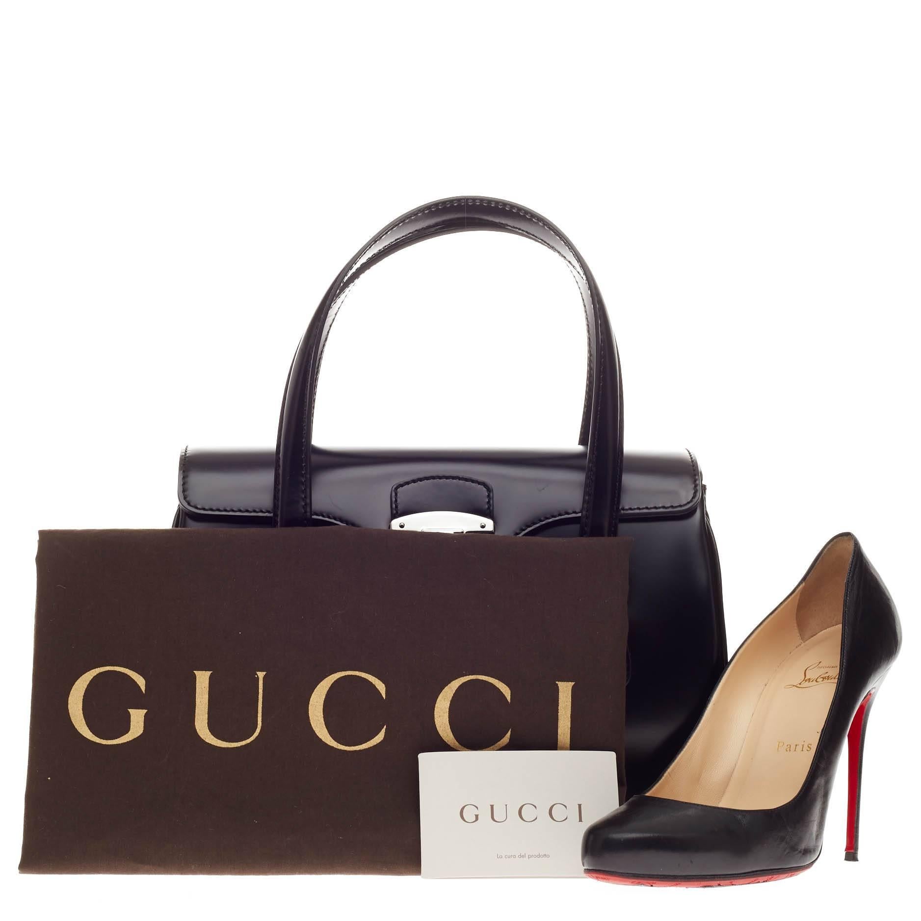 This authentic Gucci Lady Lock Satchel Leather Small is the perfect small accessory for work. Crafted in smooth and shiny black leather, this satchel features dual-top handle, retro-style lady lock closure, frontal flap, leather clochette and