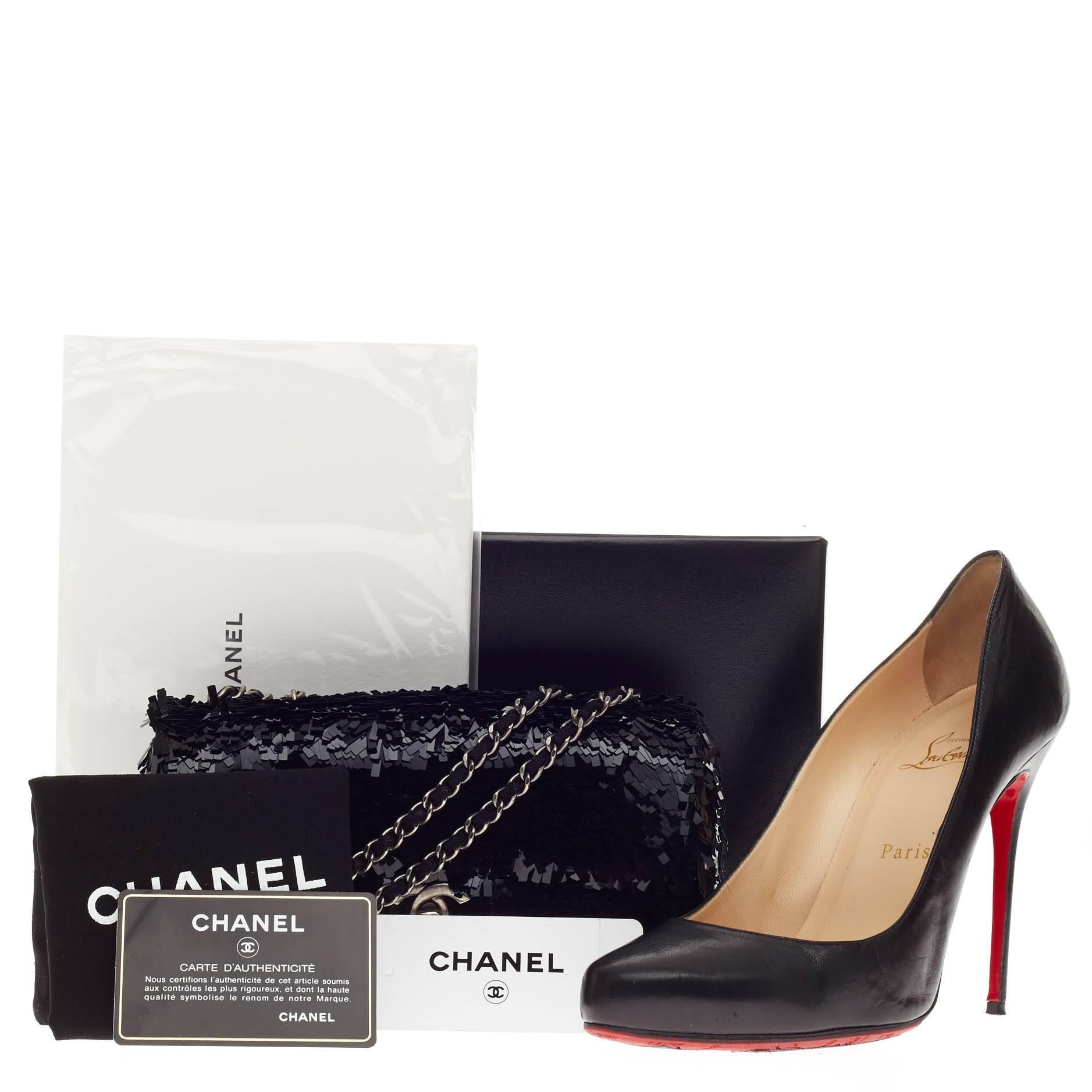 This authentic Chanel Flap Bag Embroidered Sequin Small presented in the brand's Fall/ Winter 2014 Collection is an intricate and meticulously crafted piece perfect for any Chanel lover. Embellished in beautiful, cascading black sequins, this