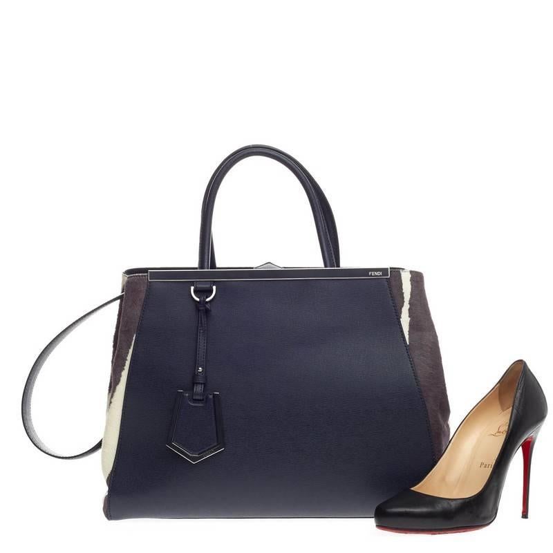 This authentic Fendi 2Jours Pony Hair and Leather Medium is impeccably stylish and structured design with a luxurious twist. Finely crafted in blue leather, plum and white pony hair sides, this popular tote features a shining top bar that dons the