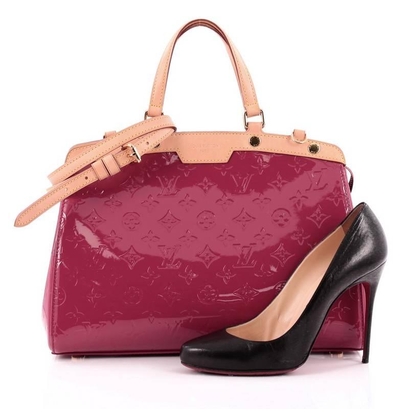 This authentic Louis Vuitton Brea Monogram Vernis MM is a staple for an everyday casual look. Crafted in indian rose pink monogram vernis with cowhide leather trims, this structured yet feminine tote features dual flat handles, stand-out yellow