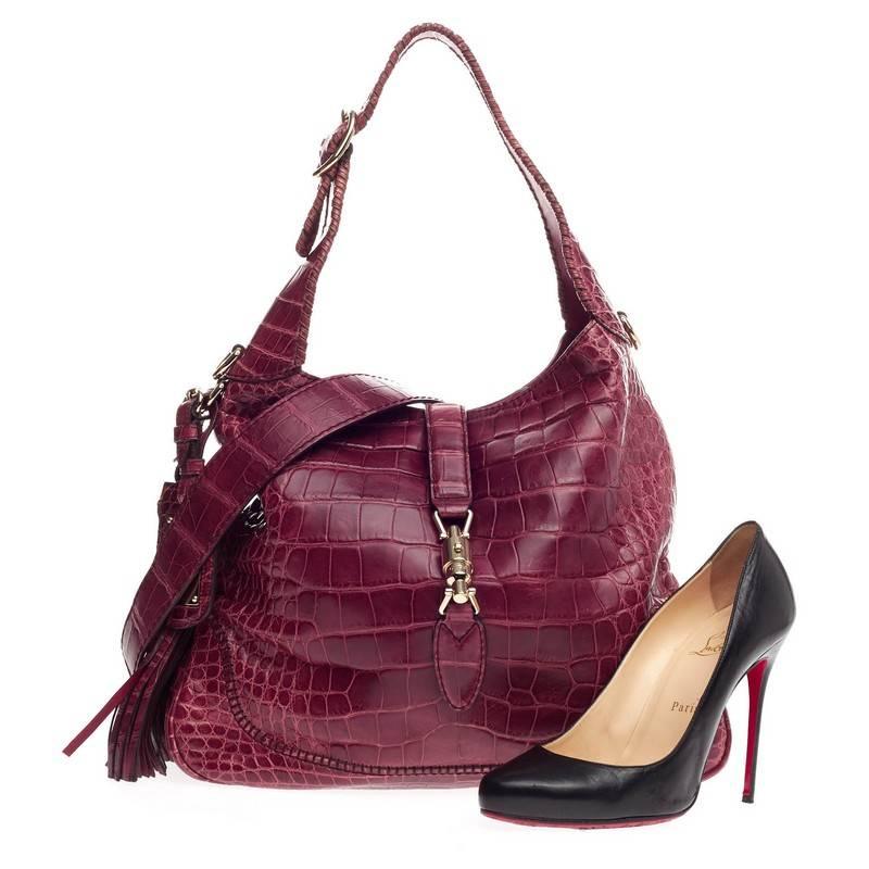 This authentic Gucci New Jackie 1921 Alligator Medium is a must-have luxurious hobo made for all Gucci lovers. Constructed from wine genuine alligator skin, this re-imagined classic bag features adjustable buckle shoulder strap with whipstitch