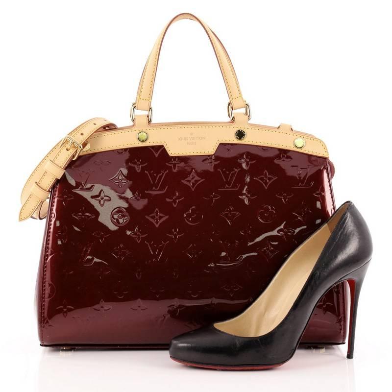 This authentic Louis Vuitton Brea Monogram Vernis MM is a staple for an everyday casual look. Crafted in rouge fauviste monogram vernis with cowhide leather trims, this structured yet feminine tote features dual flat handles, stand-out yellow