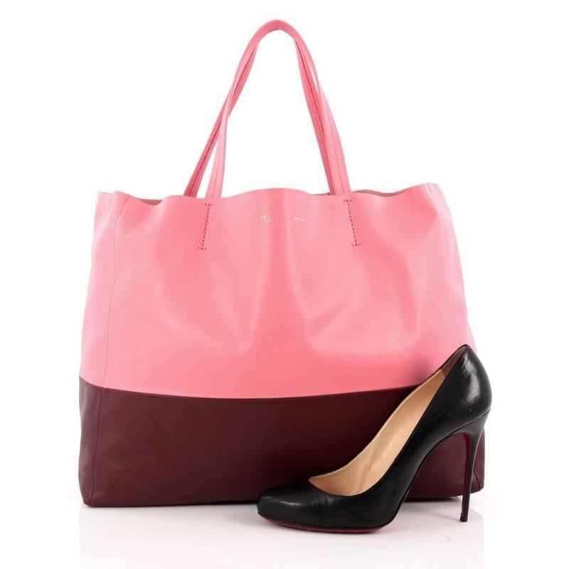 This authentic Celine Horizontal Bi-Cabas Tote Leather Large is the perfect oversized easy companion to fit all your essentials and more. Crafted in bicolor maroon and pink leather in a minimalist design, this no-fuss tote features dual flat leather