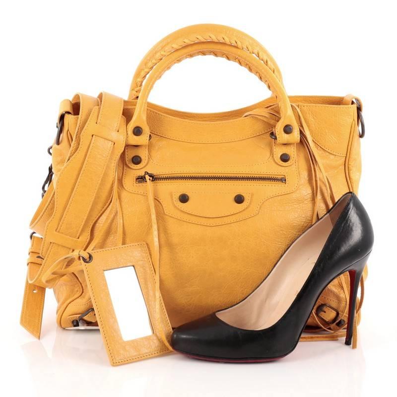 This authentic Balenciaga Velo Classic Studs Handbag Leather is a chic everyday bag. Crafted from mangue yellow leather, this stylish and functional tote features dual-rolled whipstitched handles, signature Balenciaga classic studs and buckle