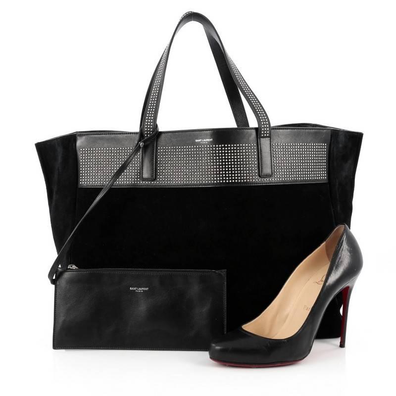 This authentic Saint Laurent Reversible East West Shopper Tote Studded Leather and Suede showcases the brand's sleek and contemporary, minimalist design perfect for everyday use. Crafted from reversible black leather and suede, this versatile tote