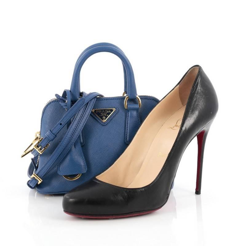 This authentic Prada Promenade Handbag Saffiano Leather Mini is the perfect little companion for an everyday stroll. Crafted from classic blue saffiano leather, this petite dome crossbody features dual-rolled handles, signature triangle Prada logo,