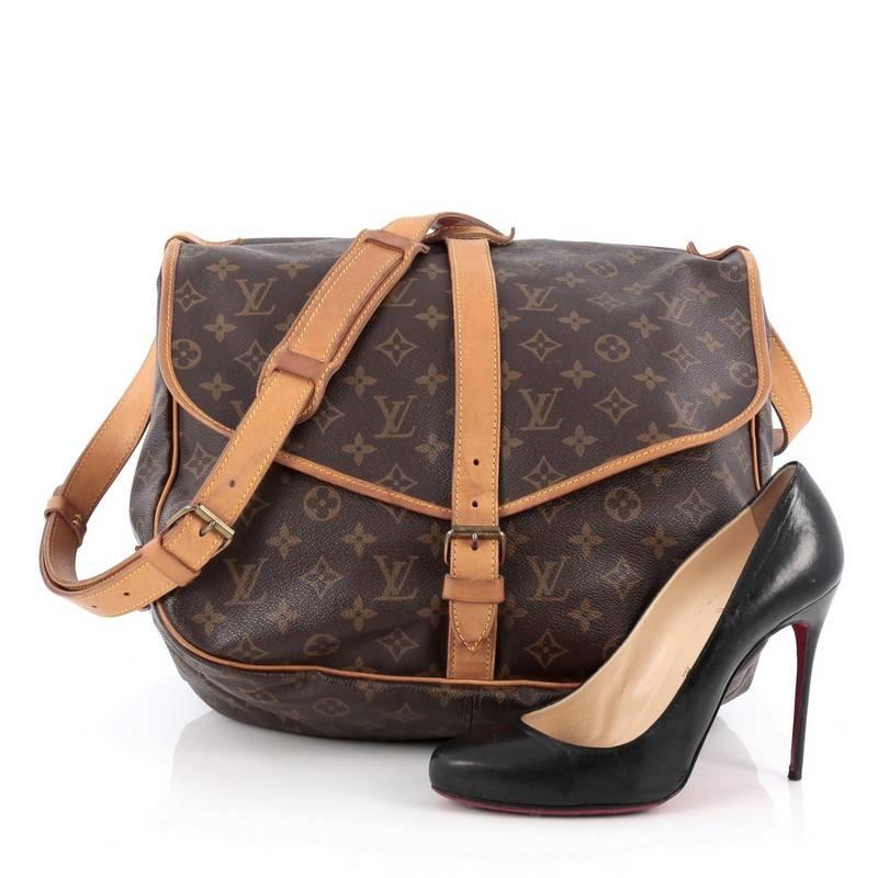 This authentic Louis Vuitton Saumur Handbag Monogram Canvas 35 showcases the brand's reinterpretation of the classic saddle bag with style and functionality. Crafted in Louis Vuitton's popular monogram coated canvas, this oversized messenger bag