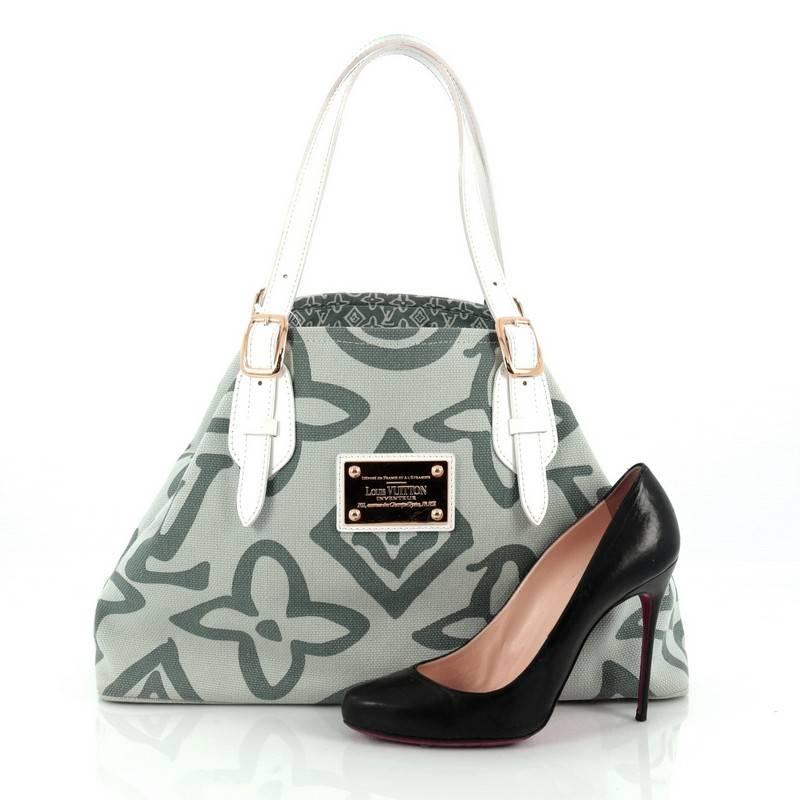 This authentic Louis Vuitton Tahitienne Cabas Canvas PM is perfect for your luxurious summer getaway. Crafted in green canvas with hand painted effect monogram print, this no-fuss tote features adjustable white leather handles with buckle detailing,