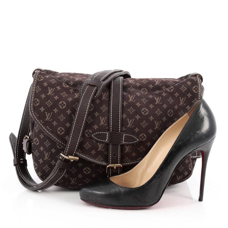 This authentic Louis Vuitton Saumur Handbag Mini Lin showcases the brand's reinterpretation of the classic saddle bag with style and functionality. Crafted in Louis Vuitton's popular brown mini lin monogram canvas, this stylish cross-body bag