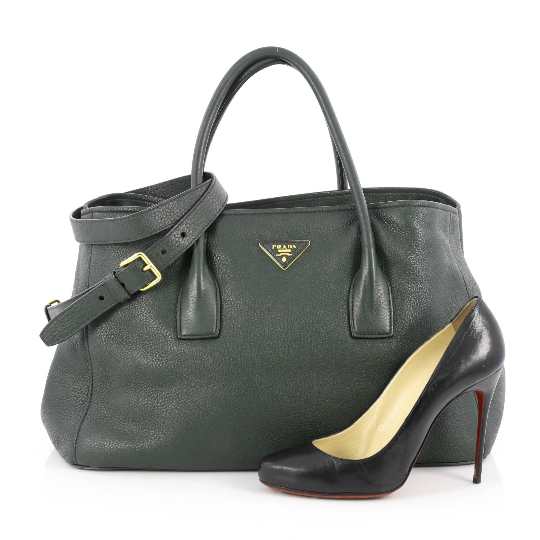 This authentic Prada East West Convertible Tote Vitello Daino Medium is elegant in its simplicity and structure. Crafted from green vitello daino leather, this tote features dual-rolled leather handles, sides with snap closures, raised Prada logo,