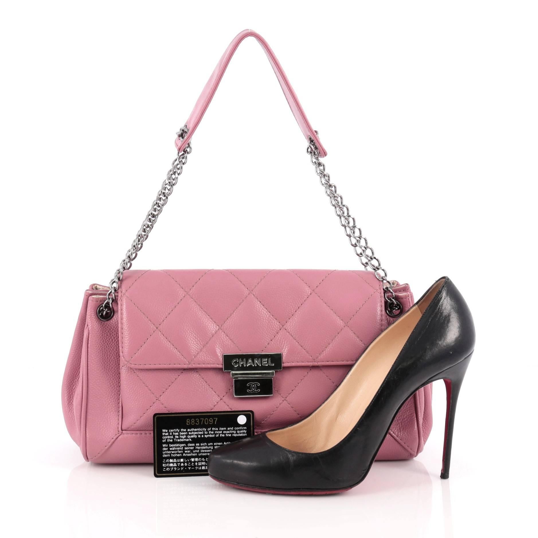 This authentic Chanel Accordion Push Lock Flap Bag Quilted Leather Medium showcases a modern and stylized design with vintage-inspired flair. Crafted from pink quilted leather, this elegant shoulder bag features accordion expanded sides, dual