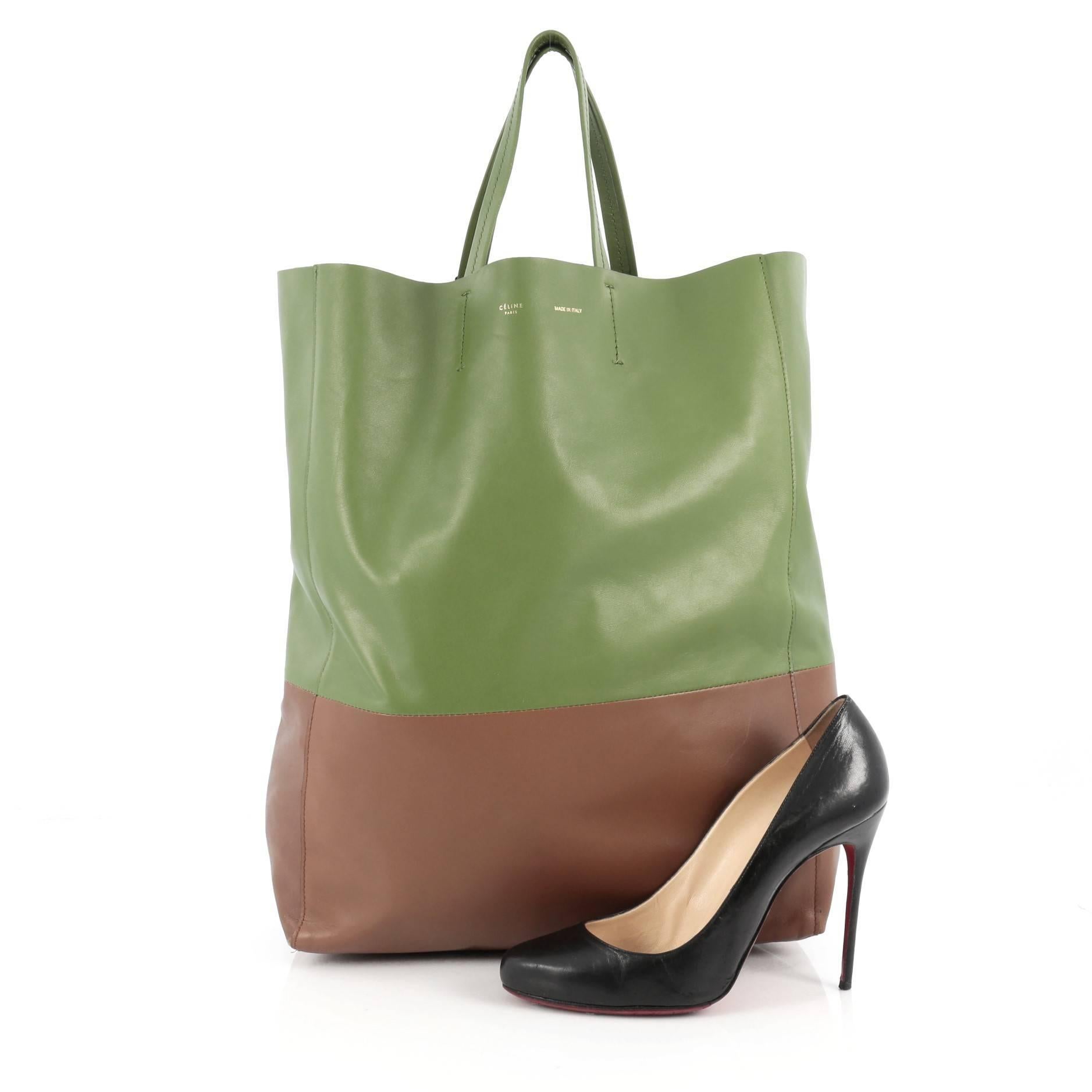 This authentic Celine Vertical Bi-Cabas Tote Leather Large is a perfect everyday accessory for the woman on-the-go. Crafted in minimalistic bi-color green and brown leather, this no-fuss tall tote features slim top handles and gold-tone hardware