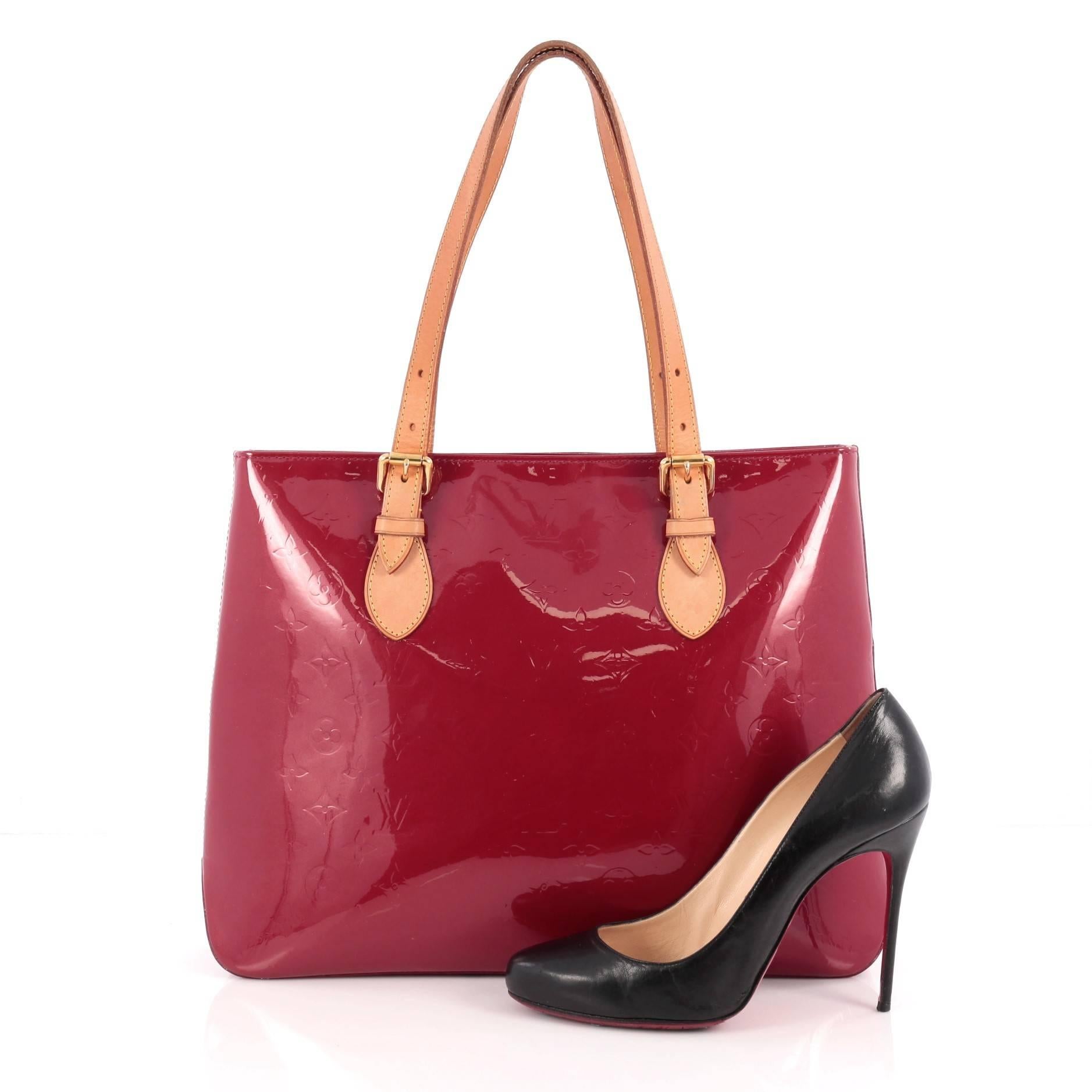 This authentic Louis Vuitton Brentwood Handbag Monogram Vernis is a stylish and functional bag made for everyday use or weekend getaways. Crafted from pomme d'amour red monogram embossed vernis leather, this tote features dual flat tall vachetta