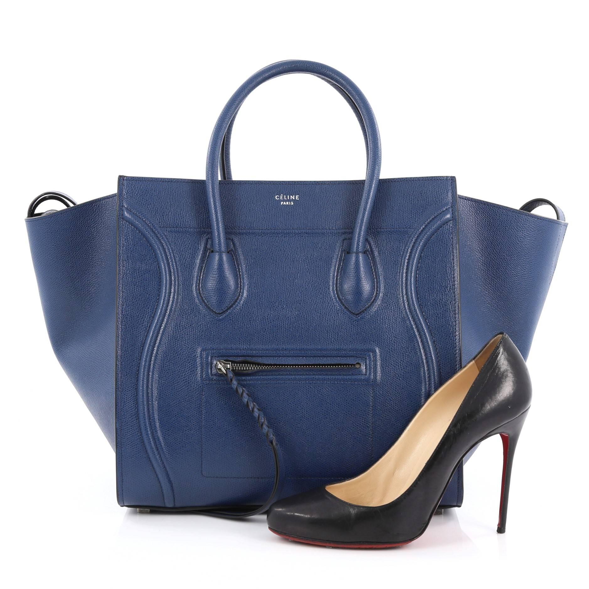 This authentic Celine Phantom Handbag Grainy Leather Medium is one of the most sought-after bags beloved by fashionistas. Crafted from blue grainy leather, this minimalist tote features dual-rolled handles, an exterior front pocket, protective base