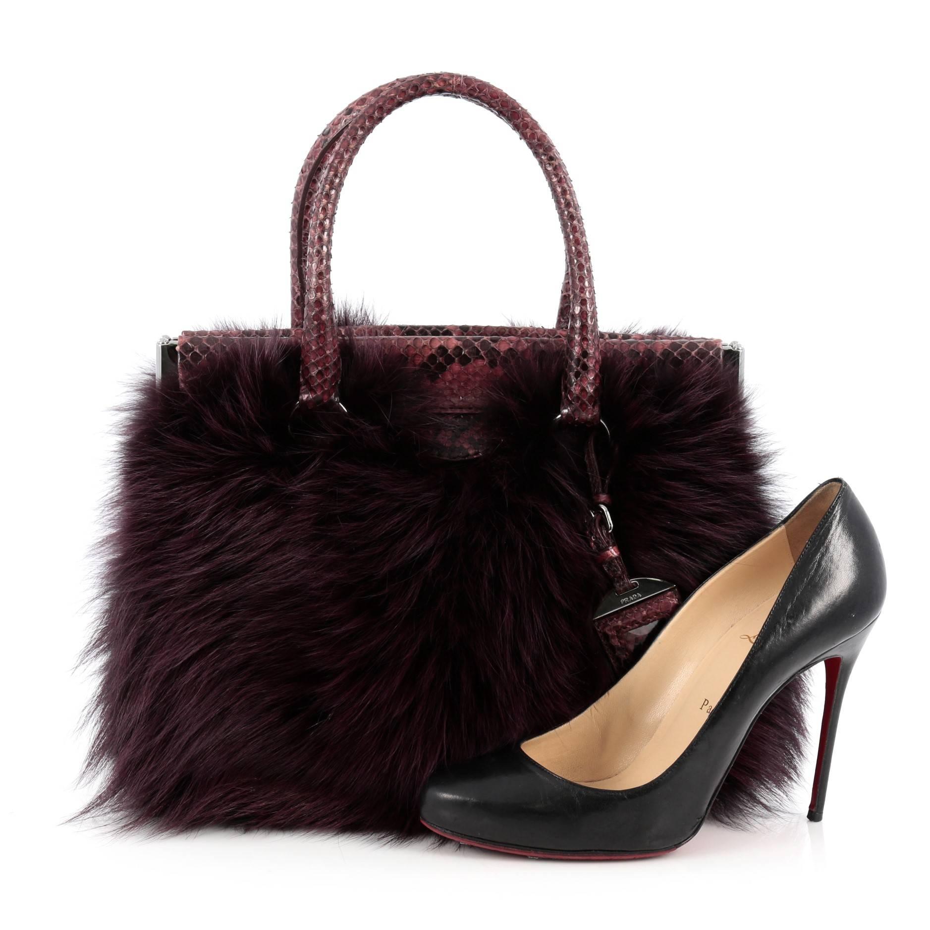 This authentic Prada Frame Satchel Fox Fur and Python Medium is a vintage-inspired, sophisticated carry-all bag with a modern twist. Crafted from genuine purple fox fur and python skin, this luxurious, exotic bag features dual-rolled python skin
