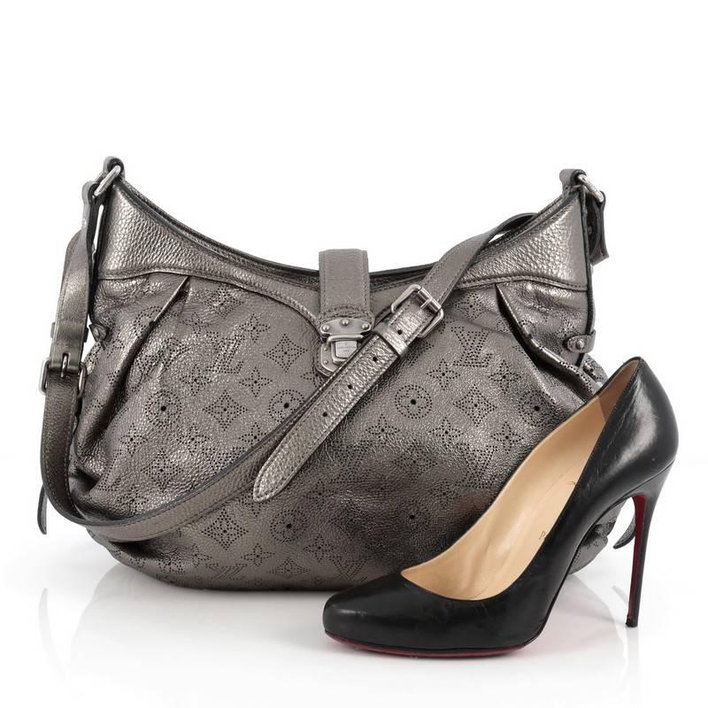 This authentic Louis Vuitton XS Crossbody Bag Mahina Leather is both stylish and functional. Crafted from metallic pewter grey perforated mahina leather, this crossbody features an adjustable leather strap, protective base studs, top flap with