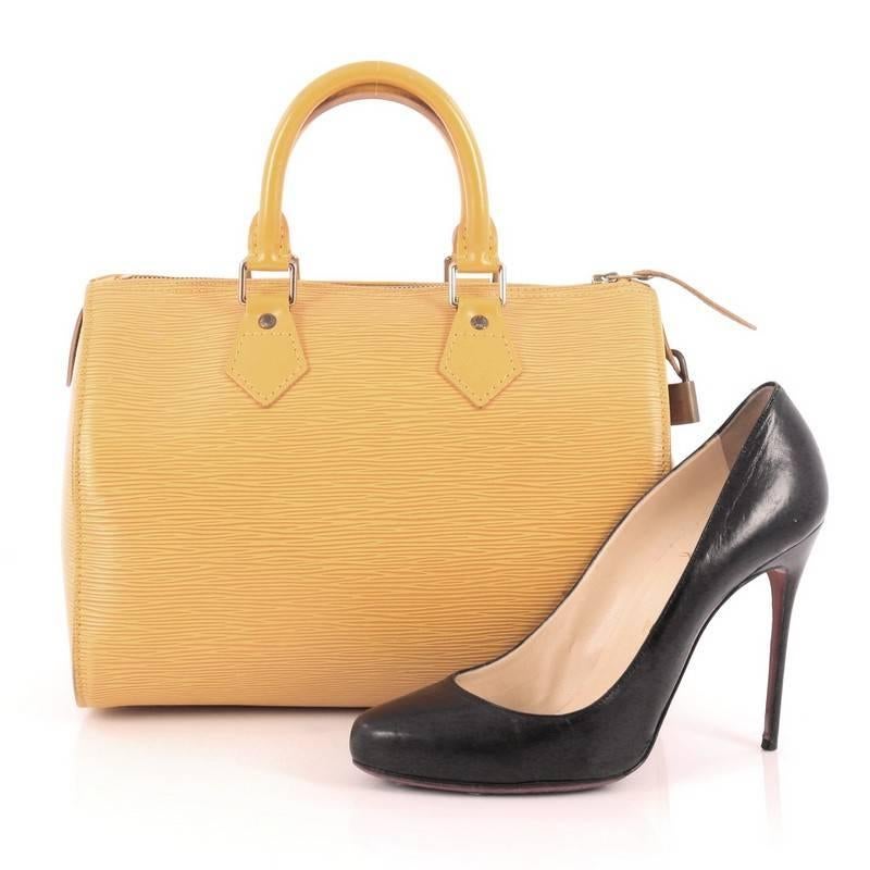 This authentic Louis Vuitton Speedy Handbag Epi Leather 30 is a timeless favorite of many. Crafted in yellow epi leather, this bag features dual-rolled handles, subtle stamped LV logo, exterior side slip pocket and gold-tone hardware accents. Its