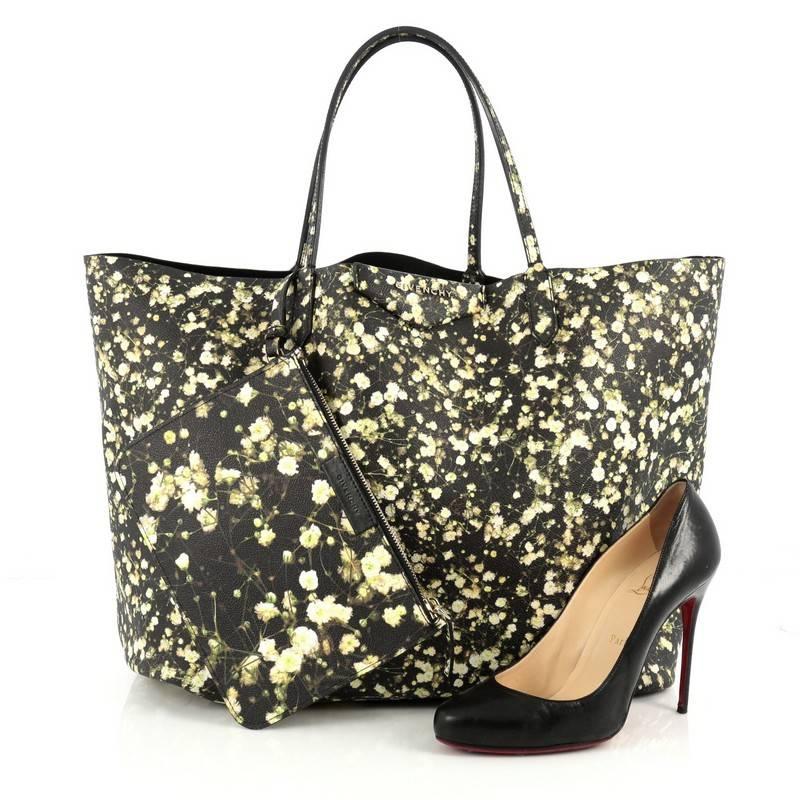 This authentic Givenchy Antigona Shopper Printed Coated Canvas Large is a statement tote made for everyday use. Crafted from yellow, green and black floral printed coated canvas, this tote features dual slim top handles, signature triangle logo at