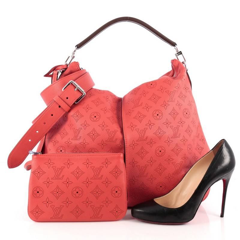 This authentic Louis Vuitton Selene Handbag Mahina Leather MM showcased in the brand's Spring/Summer 2013 collection is a luxe, feminine design. Crafted from red monogram perforated mahina leather, this beautiful hobo features an adjustable shoulder