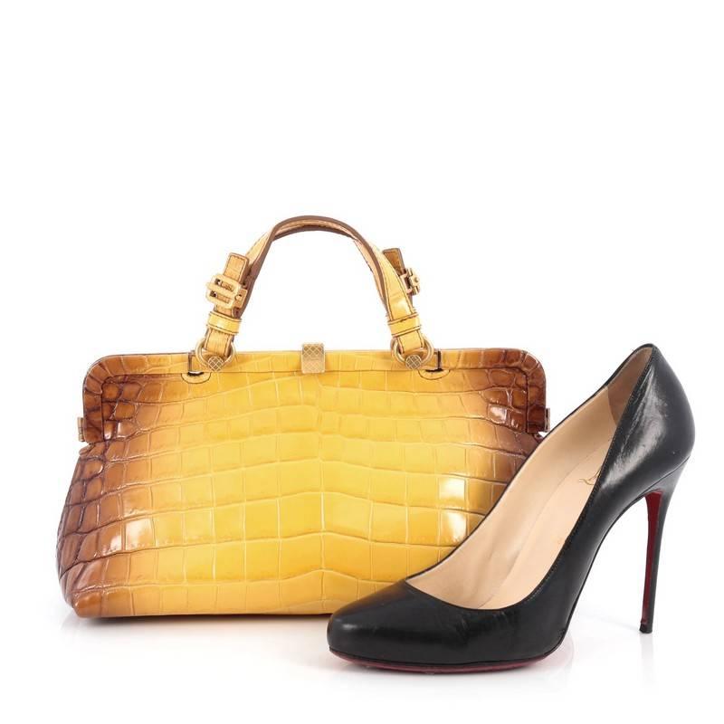 This authentic Bottega Veneta Frame Satchel Crocodile Medium displays a sophisticated design made for everyday use. Crafted from genuine brown and yellow crocodile skin, this frame bag features dual belted top handles, a frame top and gold-tone