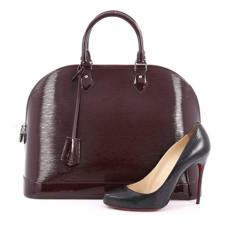 This authentic Louis Vuitton Alma Handbag Electric Epi Leather MM is elegant and as classic as they come. Constructed with Louis Vuitton's wine electric epi leather, this bag features a structured and dome-like silhouette, dual-rolled leather