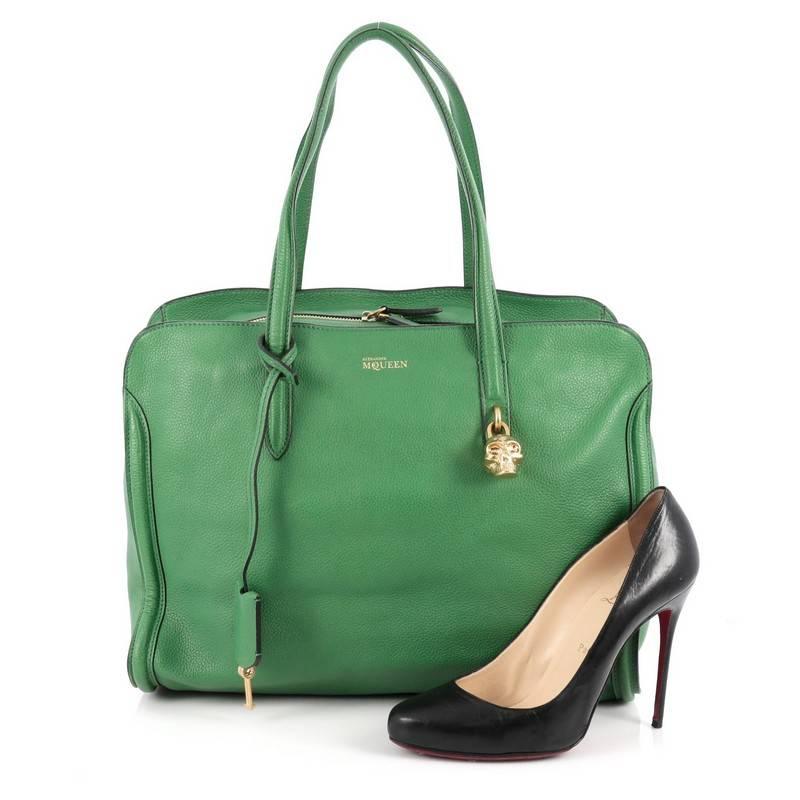 This authentic Alexander McQueen Padlock Zip Around Tote Leather Medium is a sleek and stylish accessory made for every fashionista. Crafted in green leather, this functional tote features dual leather handles, defined edges, signature gold skull
