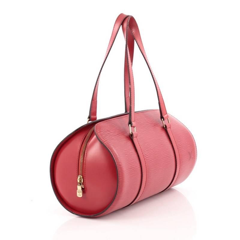 This authentic Louis Vuitton Soufflot Handbag Epi Leather is ideal for carrying daily essentials. Crafted with Louis Vuitton's rouge red epi leather, this bag features a rounded silhouette, dual-flat leather straps, subtle LV logo and gold-tone